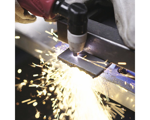 Spracovanie kovu plazmovou rezačkou pod iskrami.