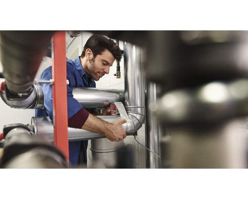 Muž obaluje potrubie tesniacou páskou.