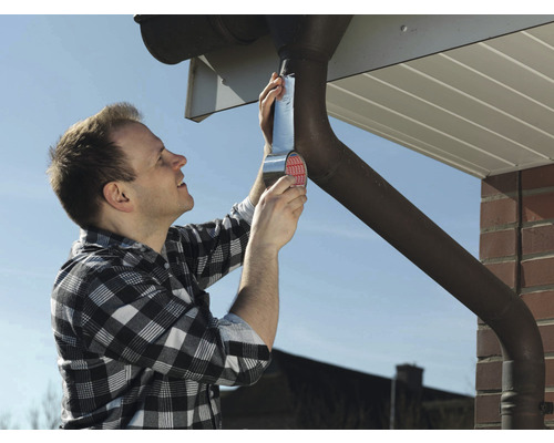 Muž opravuje odkvap pomocou tesniacej pásky.