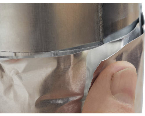 Detailný záber hliníkovej rúrky s izoláciou a rukou