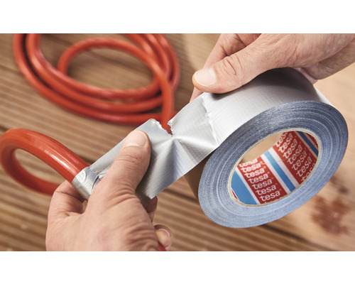 Osoba opravuje hadicu pomocou lepiacej pásky.