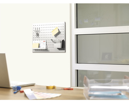 Perforovaná doska namontovaná na stene s kancelárskymi potrebami v kancelárii.