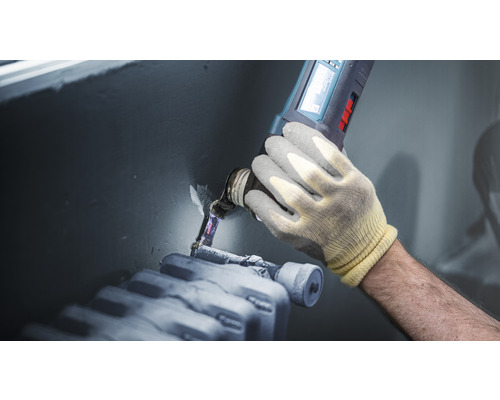 Remeselník opracováva vykurovaciu rúrku oscilačnou pílou