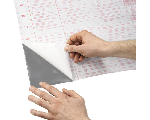 Osoba sťahuje ochrannú fóliu zo samolepiacej fólie