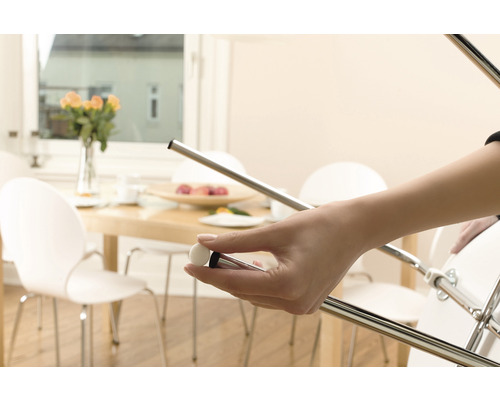 Osoba drží klzák na nábytok, ktorý sa pripevňuje na stoličku na ochranu podláh.