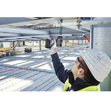 Stavebný robotník používa akumulátorový rázový uťahovák na stavenisku.