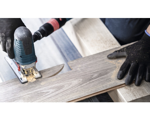 Priamočiara píla reže laminátovú dosku. Používajú sa ochranné rukavice.