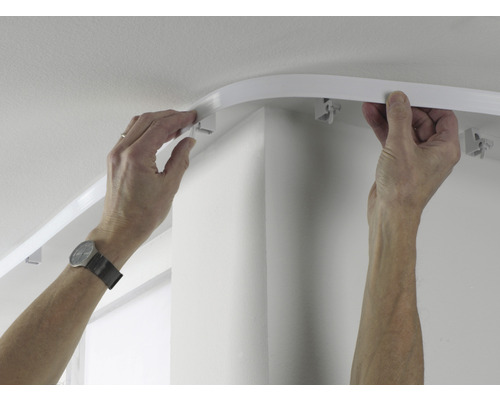 Osoba montuje záclonovú lištu na strop