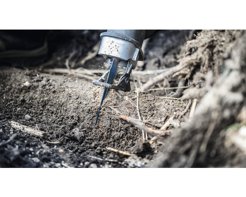 Šabľová píla reže koreň v zemi.