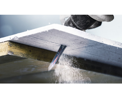 Priamočiara píla reže sadrovláknitú dosku na drevenom ráme.