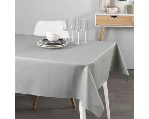 Sivý obrus na stole s riadom a pohármi.