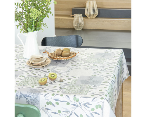 Prestretý stôl s obrusom s olivovým vzorom, riadom a dekoráciou