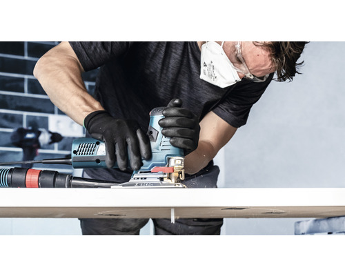 Muž pracuje s priamočiarou pílou na obrobku