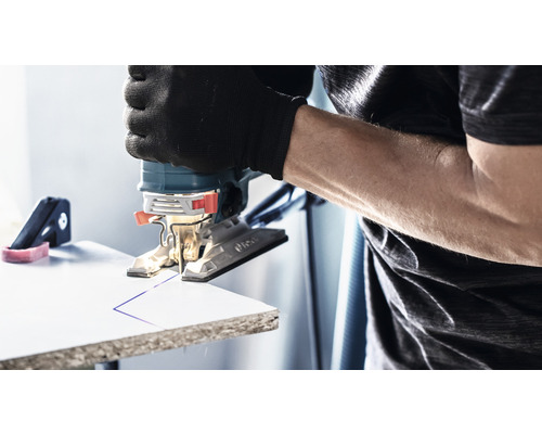 Priamočiara píla reže linku do obrobku. Používateľ má na sebe rukavice.