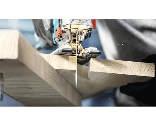 Detailný záber na priamočiaru pílu reznúcu drevenú dosku