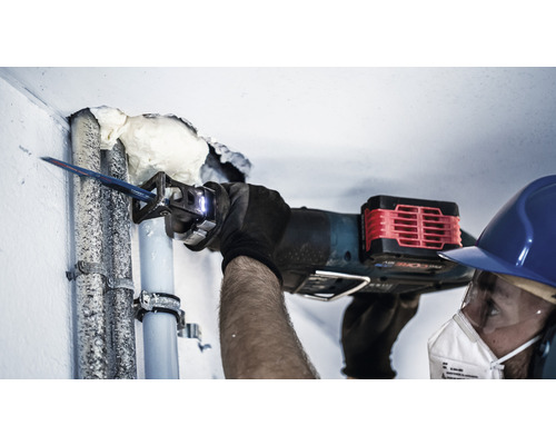 Remeselník reže rúru mečovou pílou