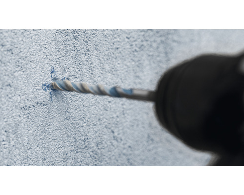 Detailný záber vŕtačky vŕtajúcej otvor do steny