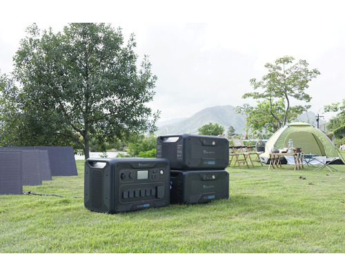 Scéna s prenosnými elektrárňami Bluetti, solárnymi panelmi a stanom na trávniku.