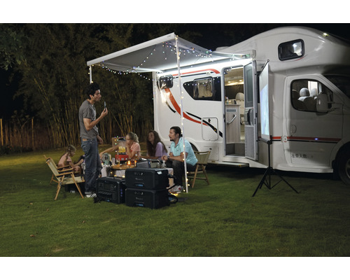 Scéna s obytným vozidlom, ľuďmi a prenosnými zdrojmi energie pre vonkajšie kempovanie