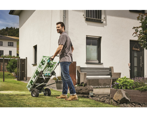 Muž prepravuje prepravky s nápojmi na rudli v záhrade.