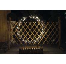 Drevený plot so svetelným oblúkom a kvetináčom v záhrade