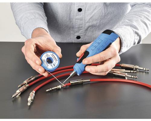 Osoba spájkuje káble pomocou spájkovačky a spájky