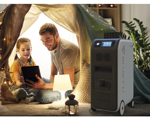 Otec a dcéra s tabletom v stane v dome, vedľa mobilná elektráreň Bluetti