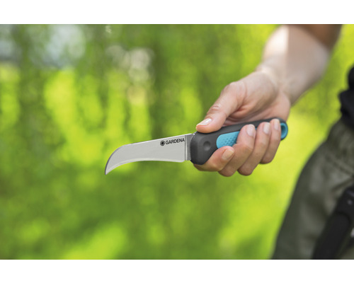 Ruka drží očkovací nôž Gardena