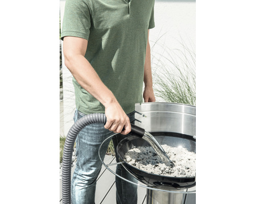 Muž vysáva popol z grilu pomocou vysávača na popol