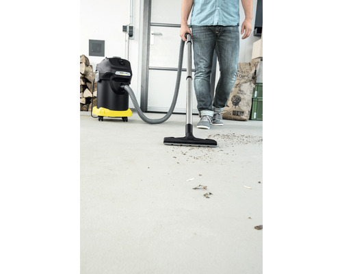 Osoba používa vysávač na mokré a suché vysávanie na čistenie podlahy.