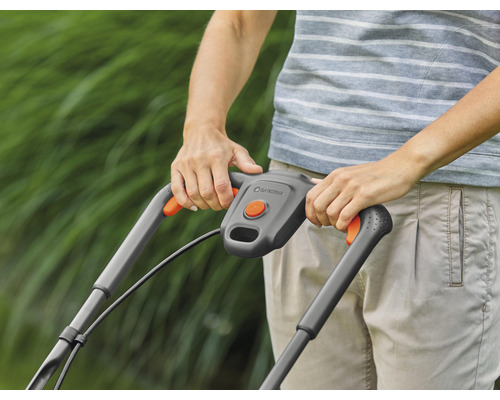 Detailný záber rukoväte kosačky na trávu s ovládacími prvkami a logom Gardena.