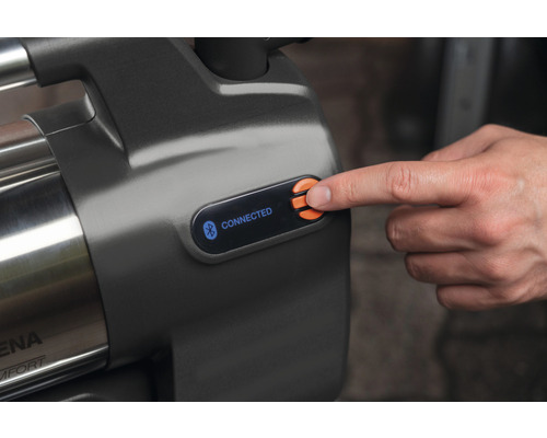 Detailný pohľad na záhradné čerpadlo s funkciou Bluetooth a ovládacím panelom, na ktorom prst stlačí tlačidlo.