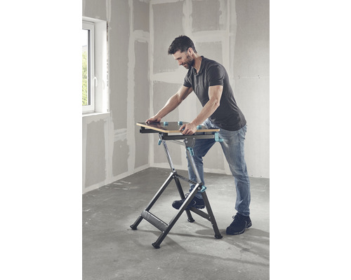 Muž používa skladací pracovný stôl v miestnosti.