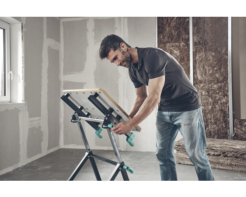 Muž pracuje na pracovnom stole Wolfcraft v nezrekonštruovanej izbe.