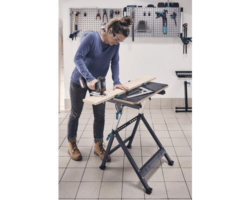 Žena pracuje s priamočiarou pílou na pracovnom stole v dielni.