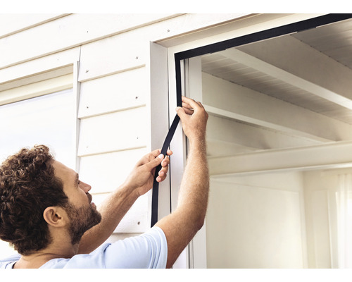 Muž inštaluje okenné tesnenie