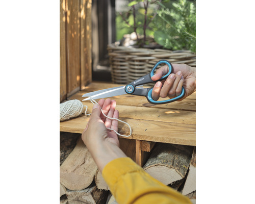 Osoba strihá šnúru záhradníckymi nožnicami Gardena.