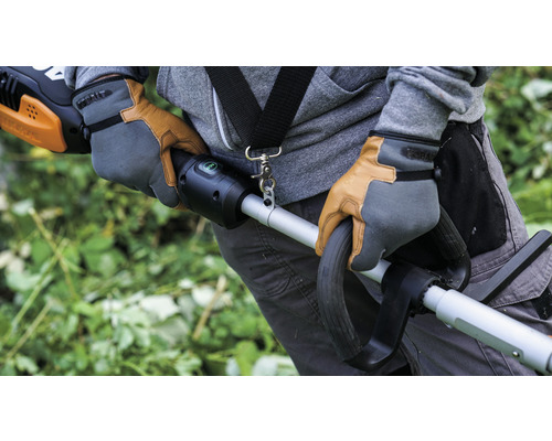 Osoba v pracovných rukaviciach obsluhuje vyžínač trávy