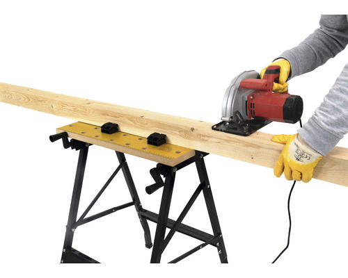 Remeselník reže drevenú dosku na pracovnom stole kotúčovou pílou.