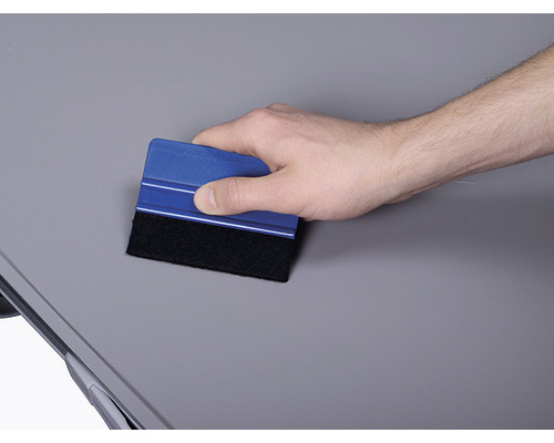 Ruka používa stierku na vyhladenie povrchu