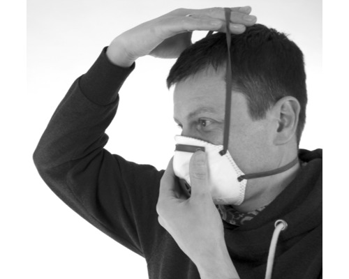 Osoba si nasadzuje respirátor.