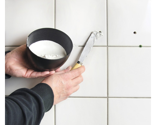 Oprava dlaždíc pomocou špachtle a výplňového materiálu