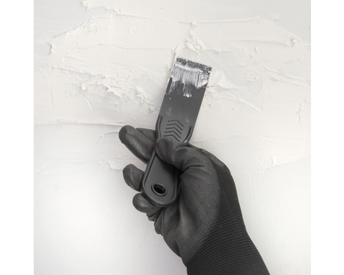 Ruka v rukavici a špachtľa pri omietaní steny