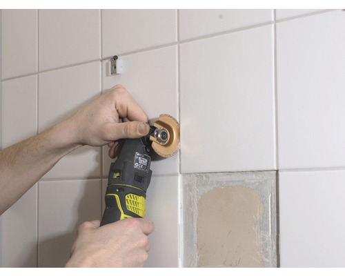 Oscilačné elektrické náradie opracováva obkladanú stenu.