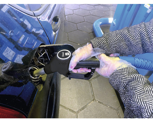 Osoba tankuje naftu do auta na čerpacej stanici