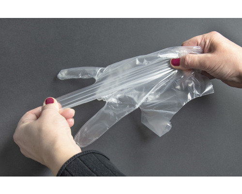 Žena si navlieka priehľadnú jednorazovú rukavicu