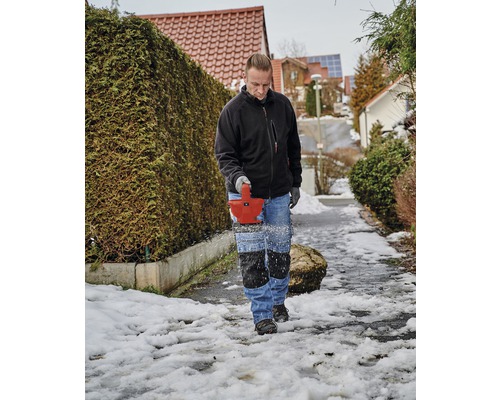 Muž odpratáva sneh snežnou frézou z chodníka