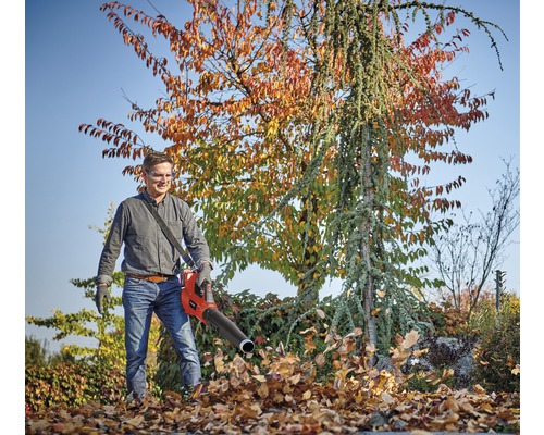 Muž používa fúkač lístia na záhradnícke práce.