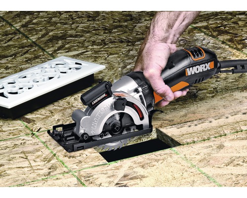 Kotúčová píla Worx pri práci na rezanie dreva s osobou, vedľa vetracia mriežka