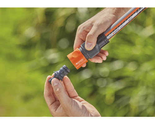 Osoba pripája záhradnú hadicu k hadicovej spojke